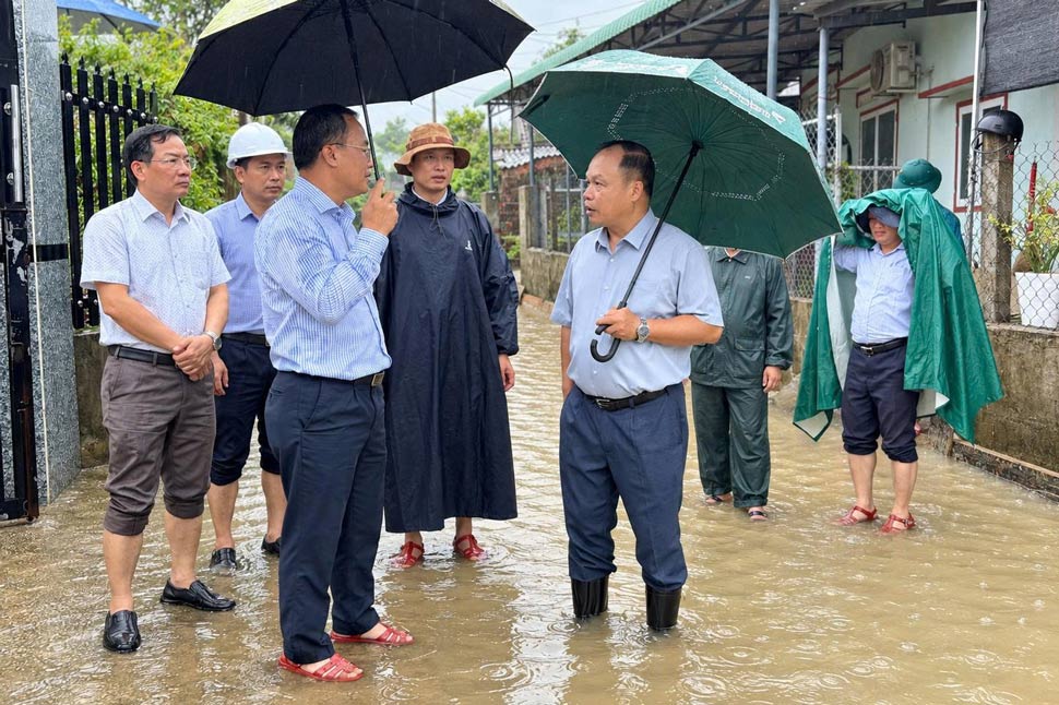 Ông Dương Mah Tiệp (cầm ô, bên phải) kiểm tra khu vực ngập tại phường Quy Nhơn Tây (chụp ngày 23.9). Ảnh: Ngọc Minh