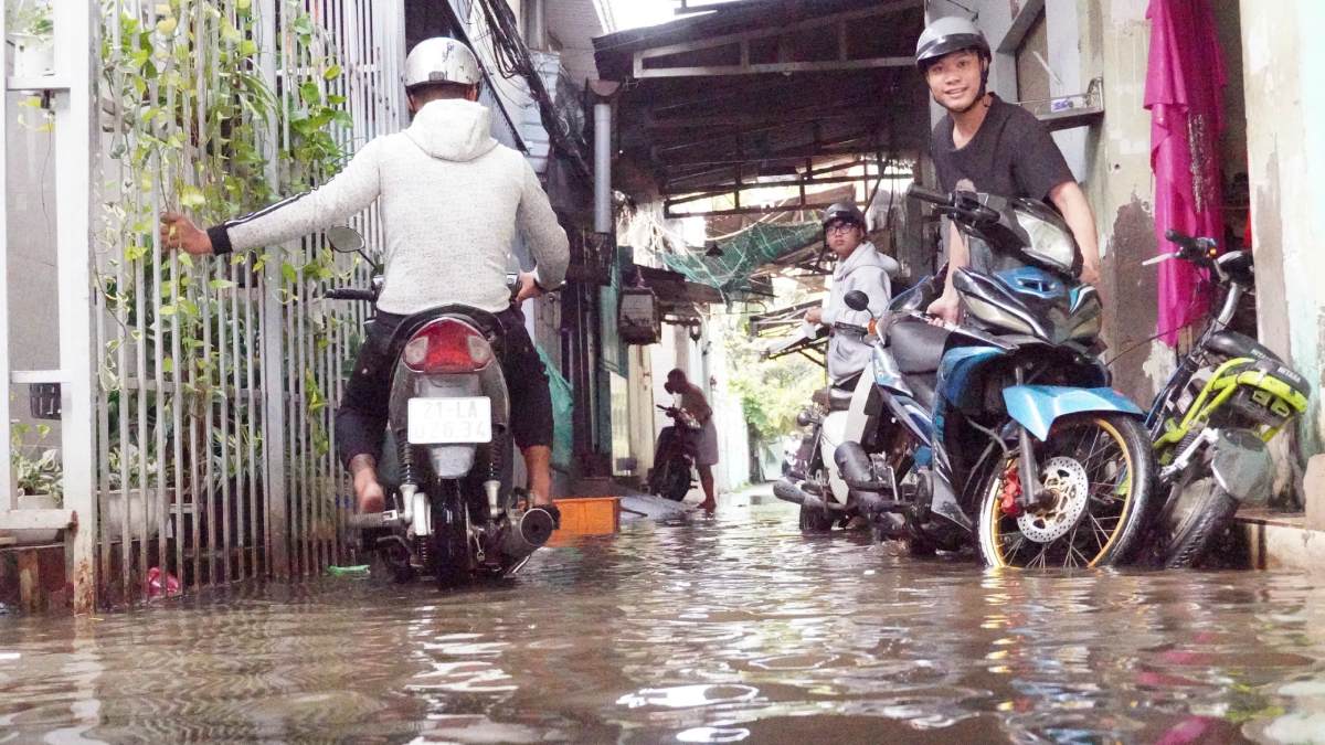 Người dân giảm tốc độ, cẩn thận di chuyển qua đoạn đường ngập nước. Ảnh: Thái Bảo