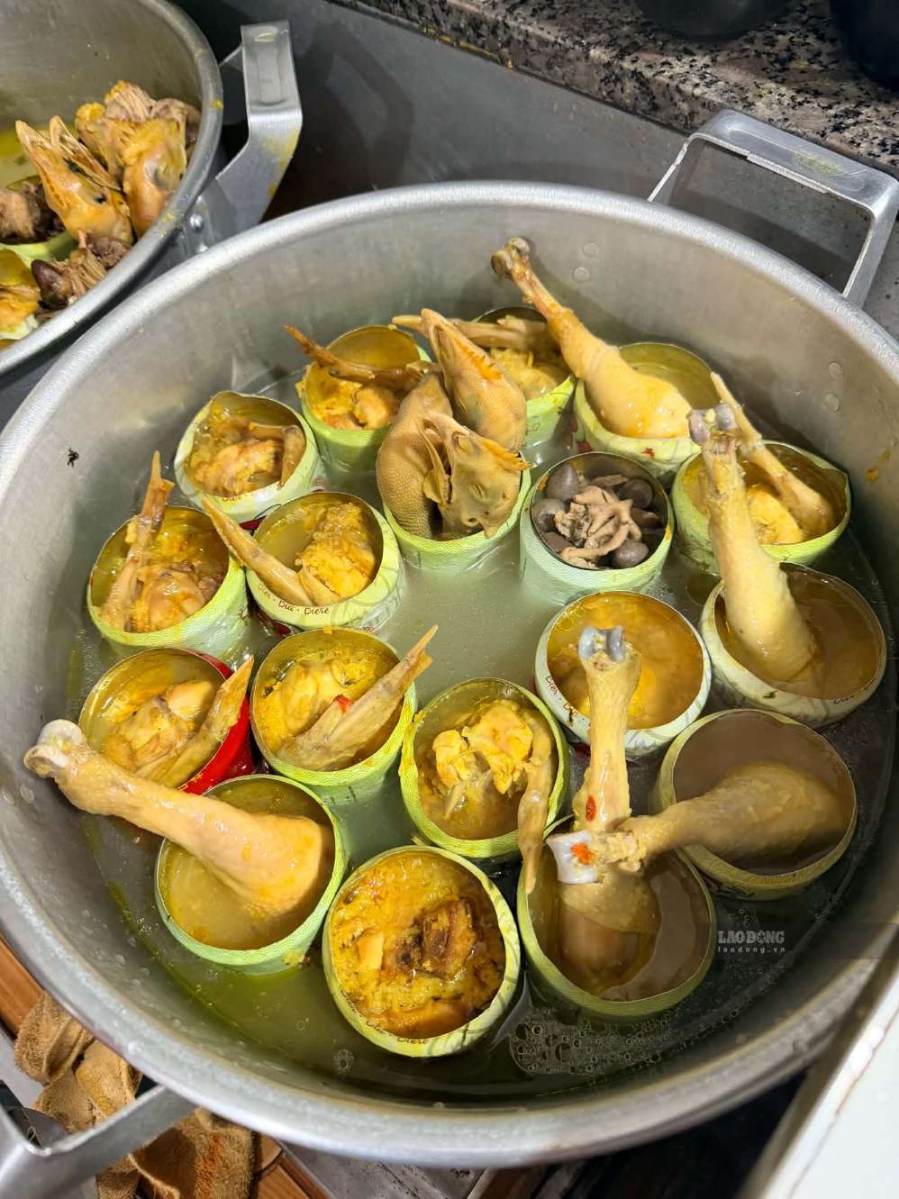 Những chiếc lon tần gà được sắp xếp trong một chiếc nồi lớn. Ảnh: Minh Trang
