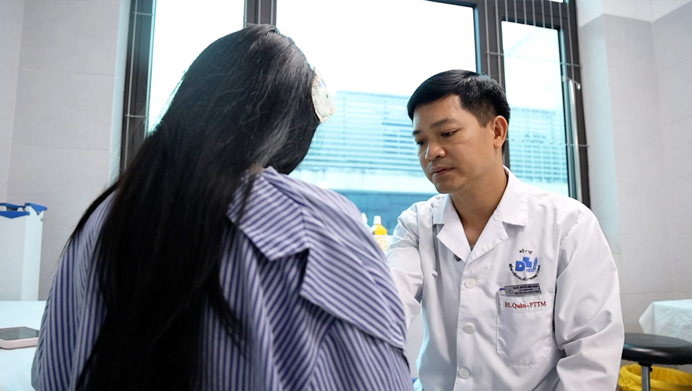 ThS.BS Nguyen Dinh Quan examina a una paciente con abscesos en ambos senos después de una inyección de relleno en casa. Foto: BVCC