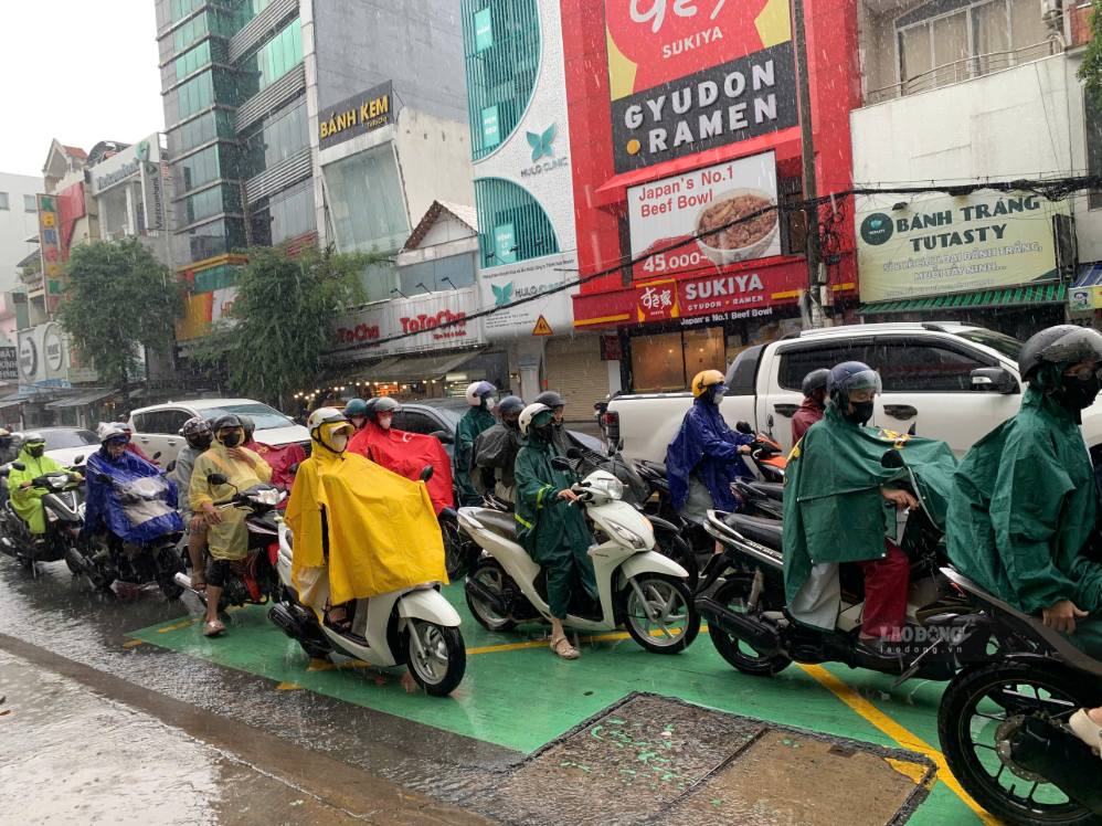 Mưa lớn xuất hiện cùng thời điểm người dân bắt đầu đi làm, đưa con đến trường sáng 30.9. Ảnh: Thái Bảo