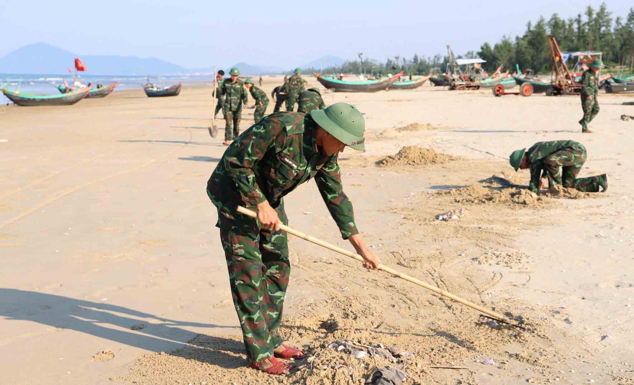 Chính quyền xã Yên Hòa phối hợp cùng cán bộ, chiến sĩ Trung đoàn 841 (thuộc Bộ Chỉ huy Quân sự tỉnh Hà Tĩnh) thu gom, chôn lấp vỏ ngao dạt vào bờ biển. Ảnh: UBND xã Yên Hòa