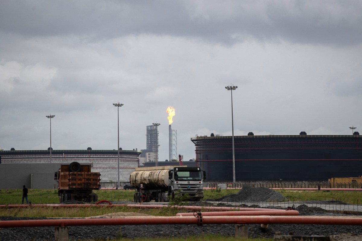 Trucks run through fuel tanks at a refinery in Nigeria. Photo: AFP