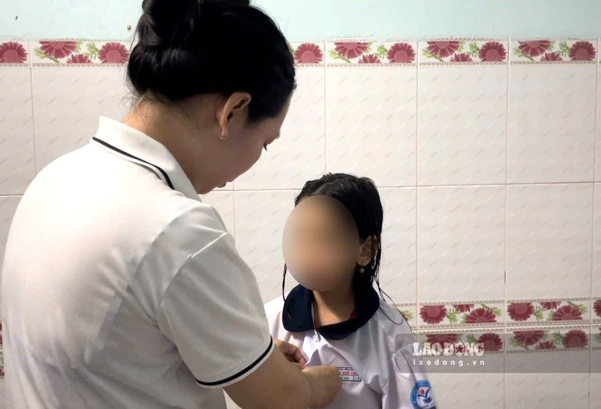 Chị Ngân thử lại bộ quần áo cho con. Ảnh: Đình Trọng