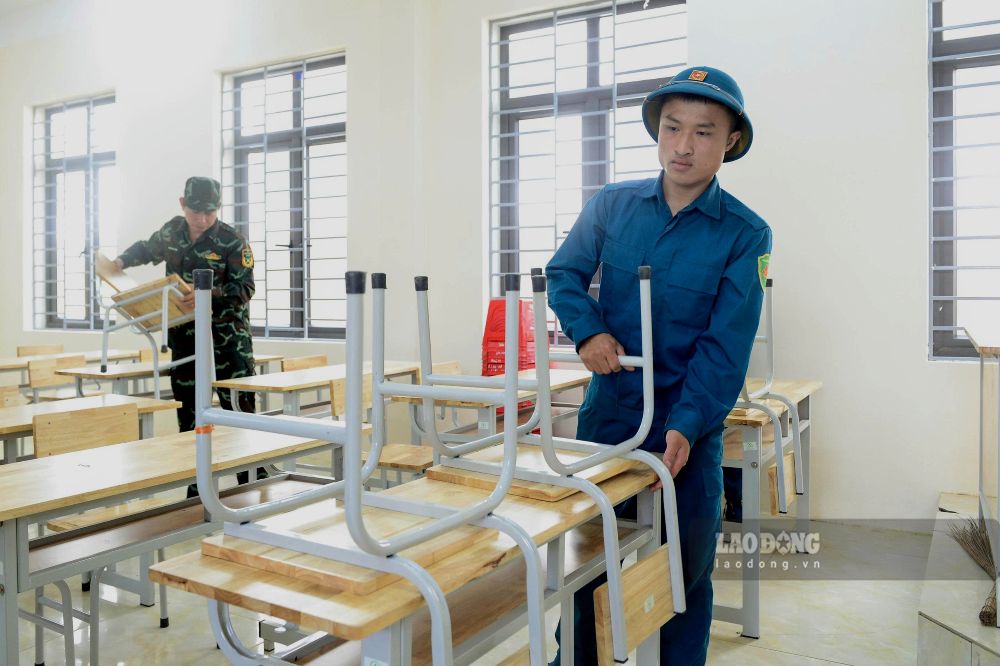 Lực lượng chức năng hỗ trợ nhà trường trong việc sắp xếp, dọn dẹp, sẵn sàng cho ngày khai giảng. Ảnh: Quách Du