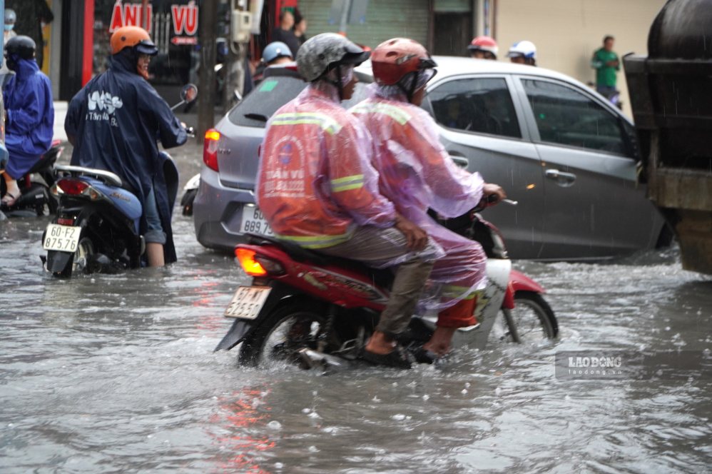 Mưa ngập nửa bánh xe khiến người dân đi lại rất khó khăn. Ảnh: HAC