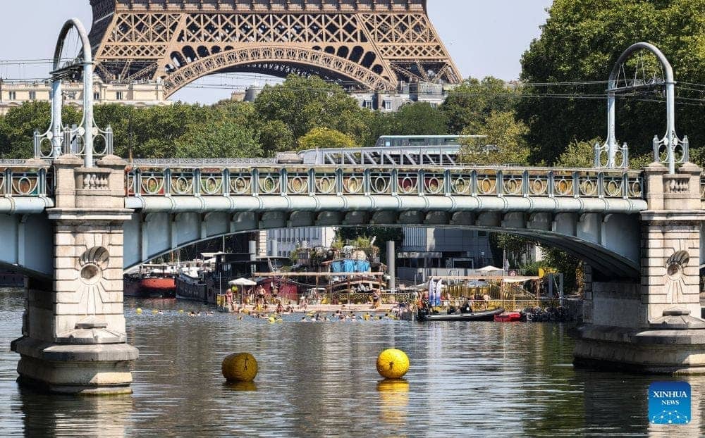 People swim on the Seine River (France) to cool off during the heat wave in Europe. Photo: Xinhua