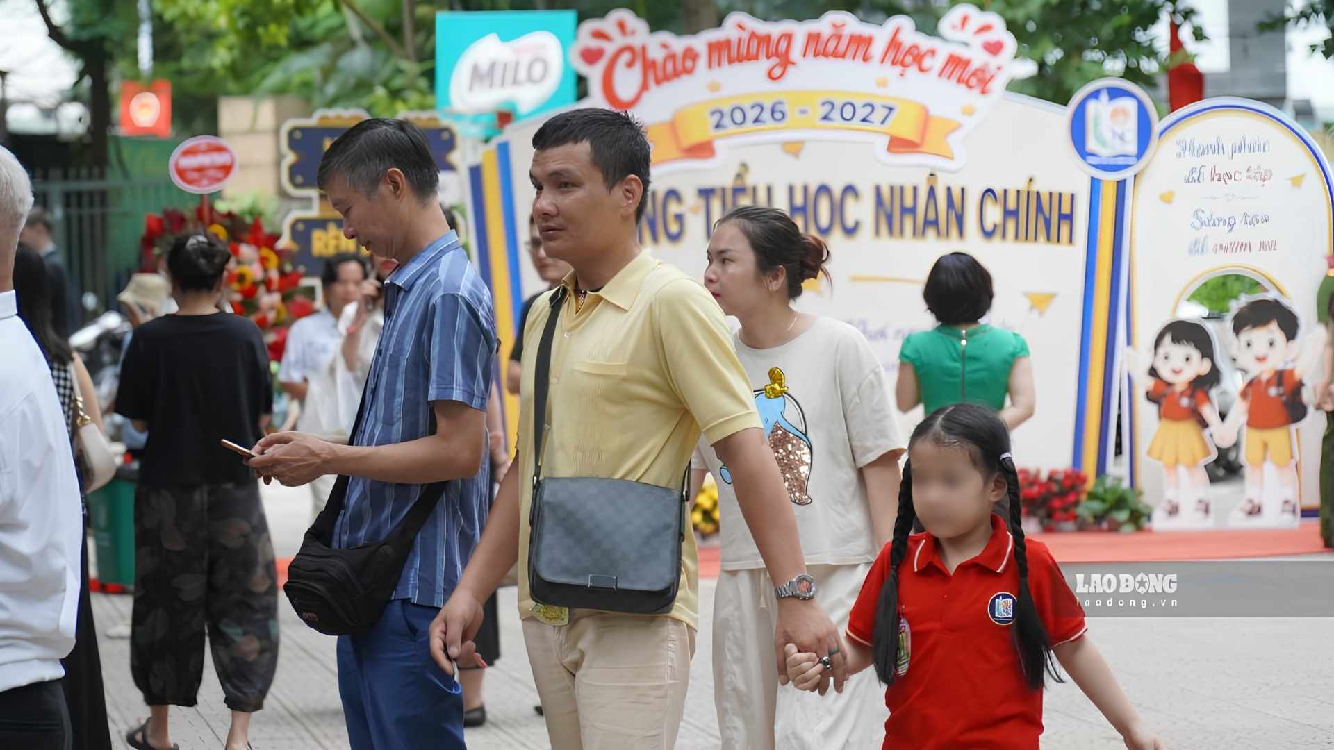 Phụ huynh ân cần dắt tay, chuẩn bị hành trang cho con trước khi bước vào lớp học. Ảnh: Minh Vũ