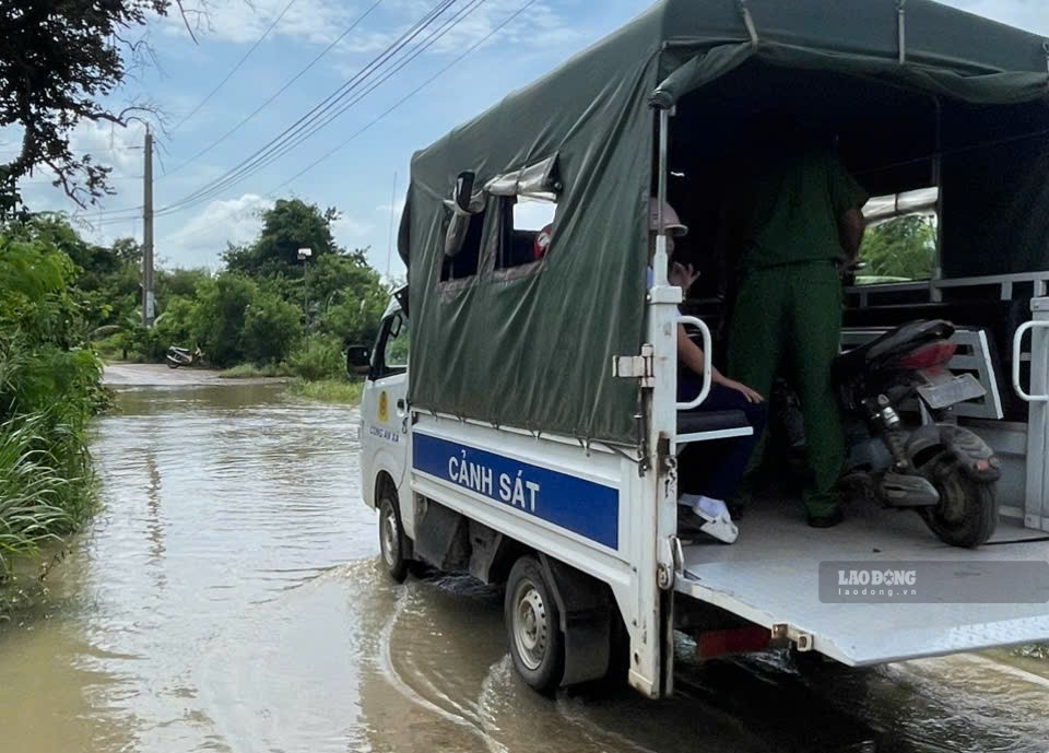 Xe công an hỗ trợ đưa học sinh qua điểm ngập. Ảnh: Duy Tuấn