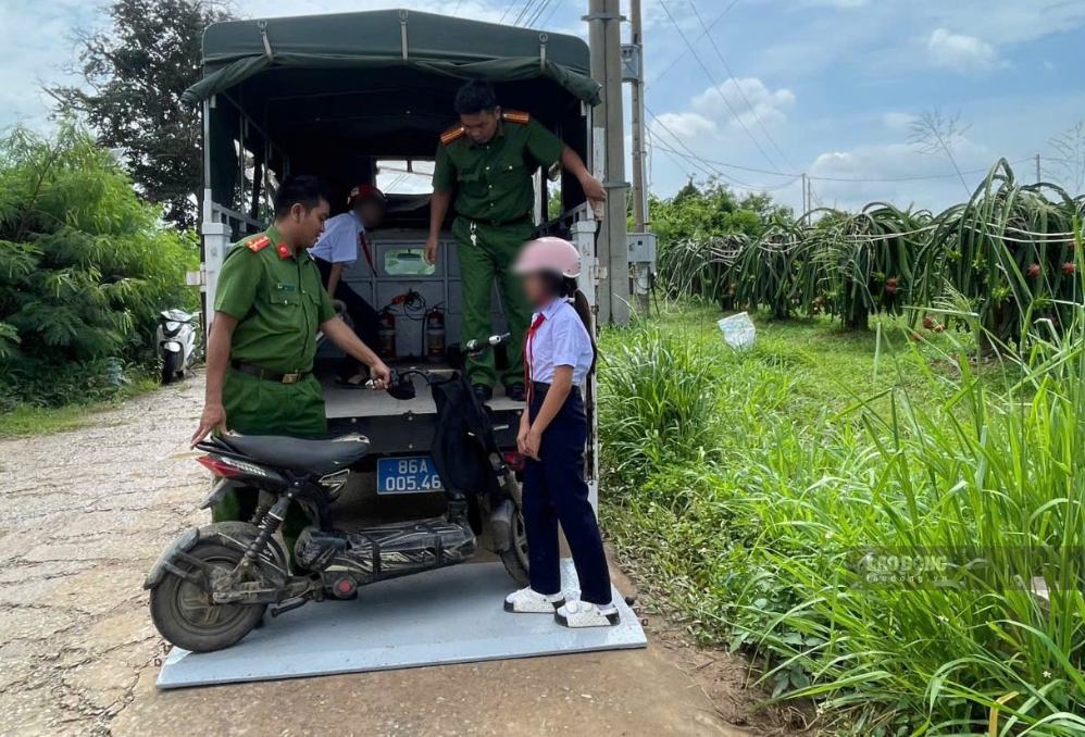 Xe đạp và các em học sinh được đưa lên xe chuyên dụng của Công an xã Hàm Thạnh để đưa qua điểm ngập. Ảnh: Duy Tuấn