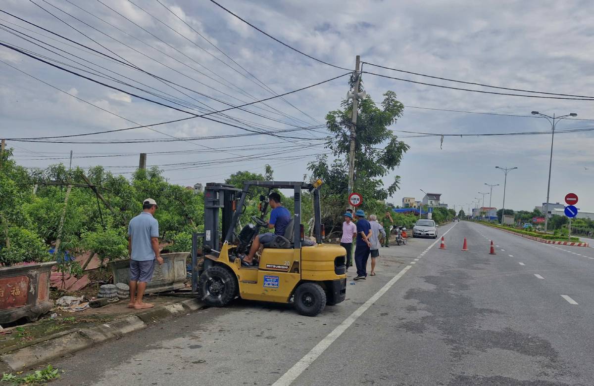 Les forces de l'ordre dégagent les pots de fleurs qui empiètent sur le couloir de circulation de la rue Lê Đức Thọ, quartier de Vị Khê, province de Ninh Bình. Photo: Quartier de Vị Khê