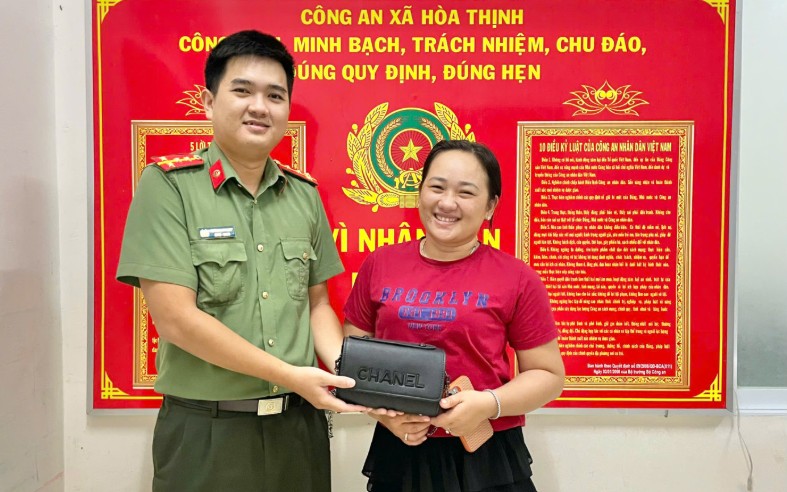 Una turista recibe sus pertenencias perdidas gracias a un estudiante de cuarto grado en Đắk Lắk que las encontró. Foto: Policía de la comuna de Hòa Thịnh