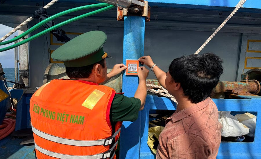 Officials of Rach Dam Border Guard Station paste QR codes on fishing boats for fishermen to scan and quickly access e-mails. Photo: Tien Vinh/An Giang Border Guard