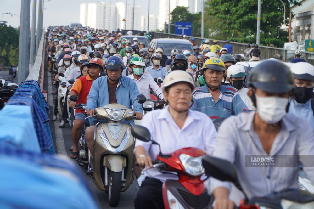 Xe máy của phụ huynh hòa cùng dòng phương tiện đi làm trên đường phố TPHCM. Ảnh: Chân Phúc