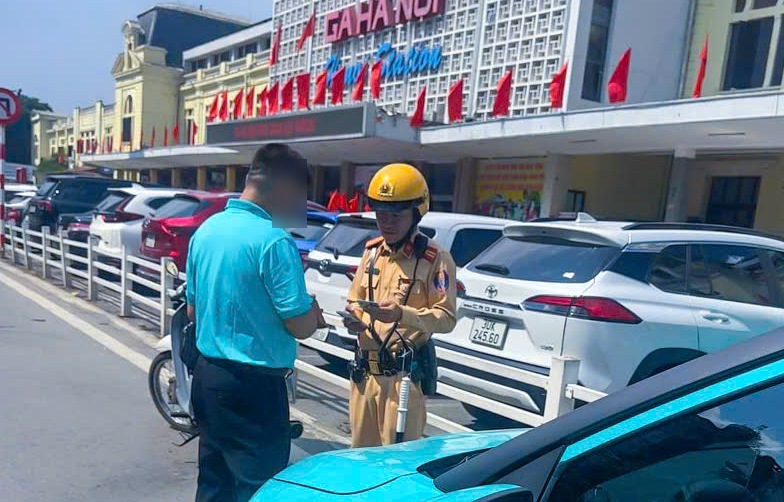 Traffic police handle cars parked illegally. Photo: Hanoi Traffic Police Department