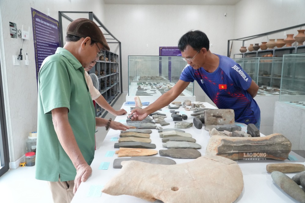 El Sr. Tuan (derecha) presenta a los investigadores las antigüedades expuestas en el Museo de Antigüedades de Vietnam en la comuna de Tinh Khe, provincia de Quang Ngai. Foto: Vien Nguyen