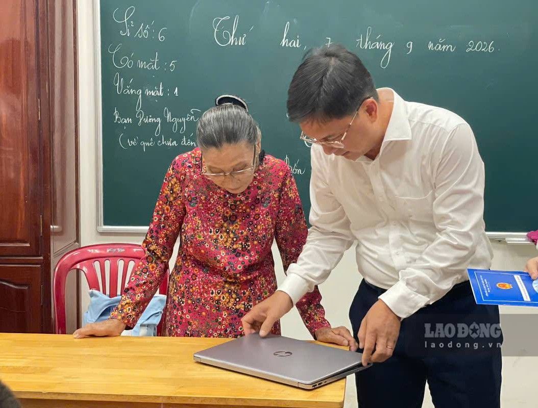 Ông Nguyễn Mạnh Cường tặng cô Ba chiếc máy tính để cô giảng dạy cho học sinh. Ảnh: Đình Trọng