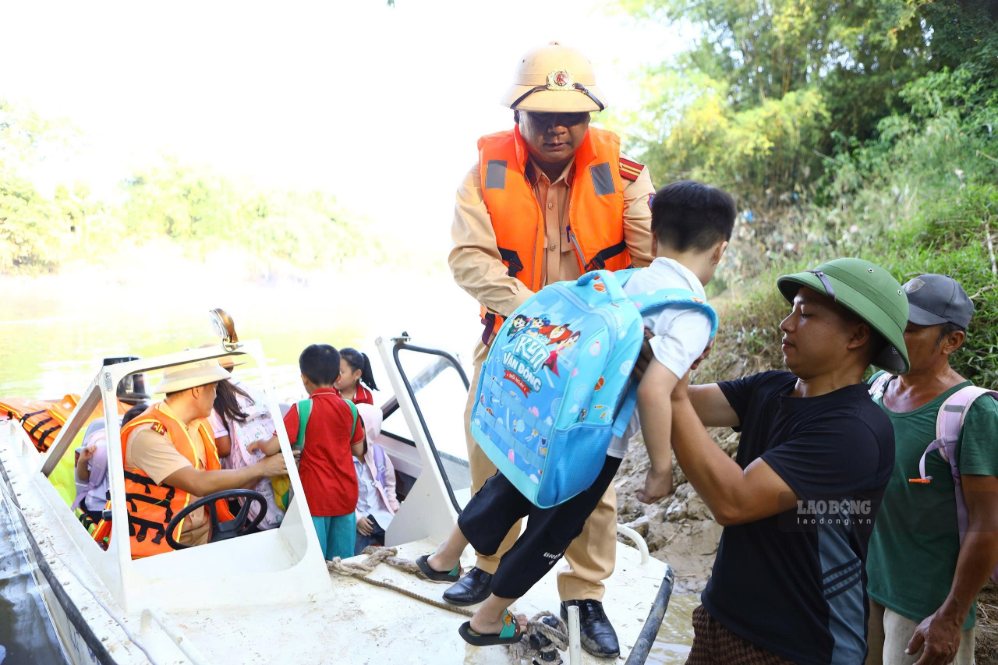 Lực lượng chức năng dùng cano đưa đón học sinh tới trường trong ngày 8.9. Ảnh: Việt Bắc