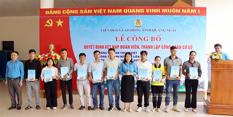 Ms. Nguyen Thi Viet Hien - Vice President of the Quang Ngai Provincial Labor Federation (5th from right) presents the Decision to admit union members. Photo: Quoc Chinh