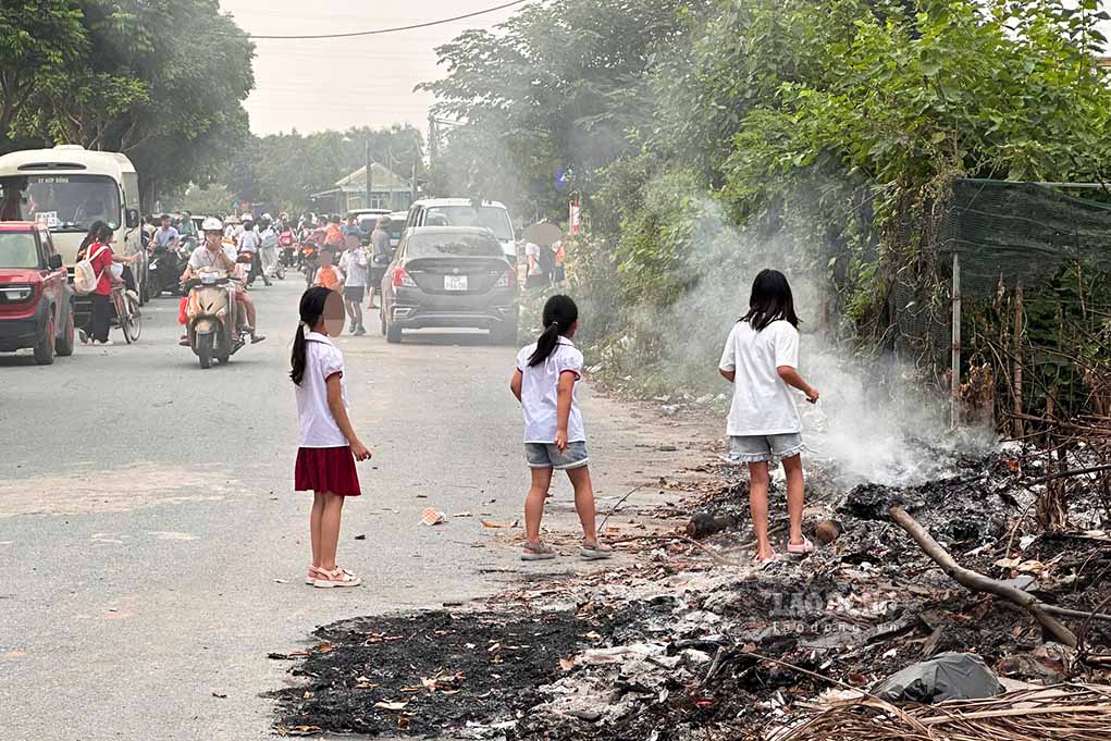 Trẻ nhỏ, học sinh vui chơi ngay cạnh điểm tập kết rác thải đang bốc khói nghi ngút. Ảnh chụp chiều 8.9: Hữu Vũ