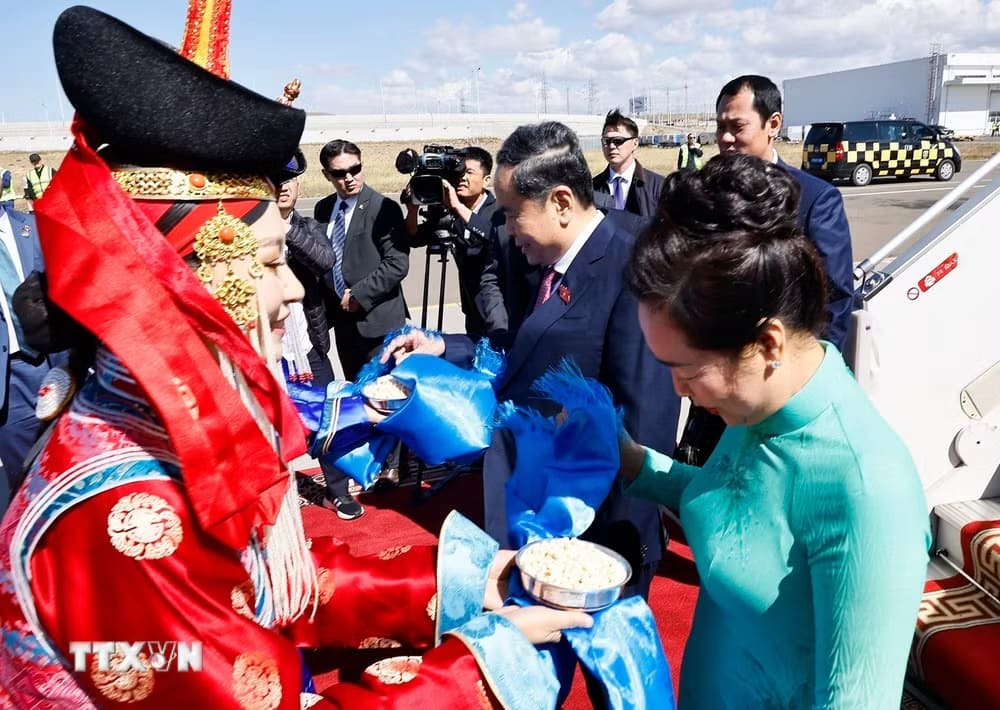Hai thiếu nữ Mông Cổ tặng khăn Khadag và mời Ủy Bộ Chính trị, Chủ tịch Quốc hội Trần Thanh Mẫn và Phu nhân dùng bánh Aaruul theo nghi thức đón khách truyền thống của Mông Cổ. Ảnh: Doãn Tấn/TTXVN