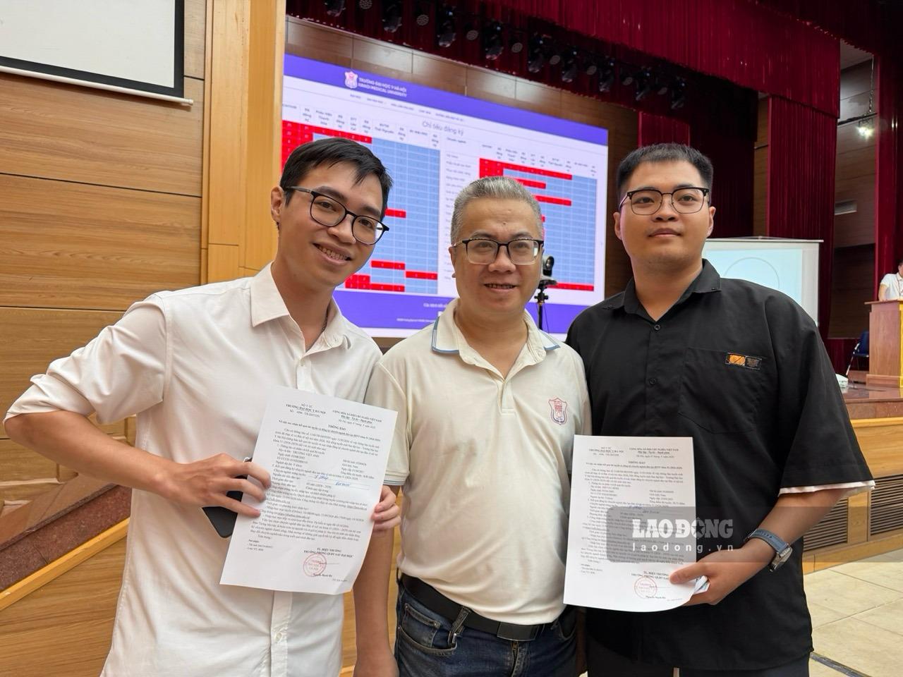 Doctor Truong Viet Anh (left) and Do Tat Binh (right) take photos with their teacher welcoming them back to the medical field at Match Day 2026. Photo: Thuy Linh