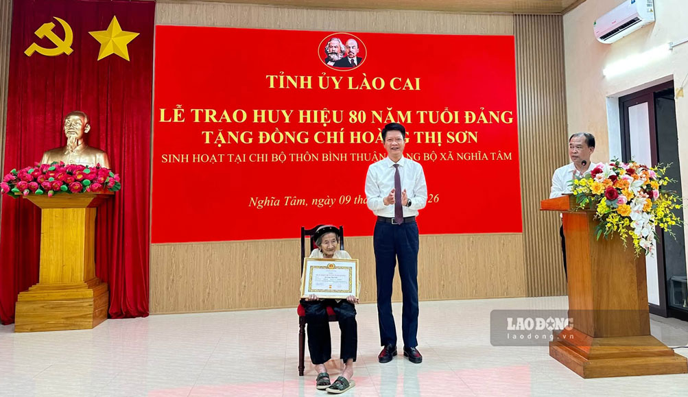 Mr. Nguyen The Phuoc - Chairman of the Vietnam Fatherland Front Committee of Lao Cai province - awarded the 80-year Party Badge and presented flowers to congratulate Ms. Hoang Thi Son on the afternoon of September 9. Photo: Nghia Tam