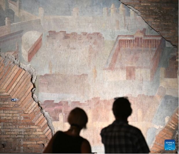 Du khách chiêm ngưỡng bức bích họa cổ “Painted City” bên trong hành lang ngầm của khu phức hợp tại Rome ngày 8.9.2026. Ảnh: Xinhua