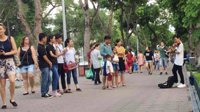 Con trai chị Hằng trong một lần chơi đàn violon ở phố đi bộ Hà Nội. Ảnh: FBNV