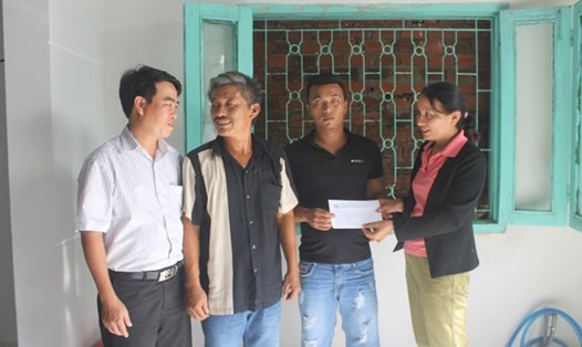 Đại diện Quỹ XHTT Tấm Lòng Vàng (trái) trao tiền hỗ trợ cho hai cha con ngư dân Trần Văn Tâm (phường 6, TP Tuy Hòa, Phú Yên). Ảnh: N.Băng