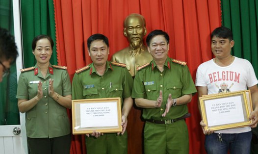 "Hiệp sĩ" Nguyễn Thanh Hải (bìa phải) thay mặt nhóm "hiệp sĩ" lên nhận tiền thưởng. Ảnh: H.H
