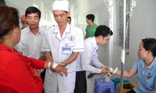 Nhân viên y tế BVĐK Châu Thành tháo kim truyền dịch cho công nhân tái nhập viện. Ảnh: PV