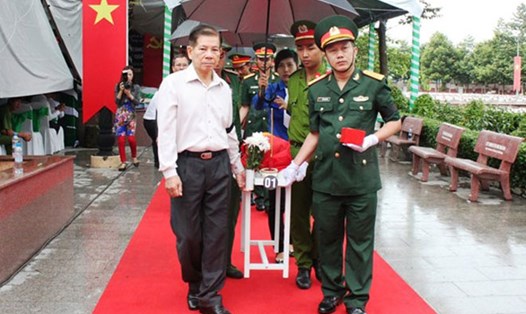 Ông Nguyễn Minh Triết, nguyên Ủy viên Bộ Chính trị, nguyên Chủ tịch Nước (trái) đưa hài cốt liệt sĩ về nơi an nghỉ.
