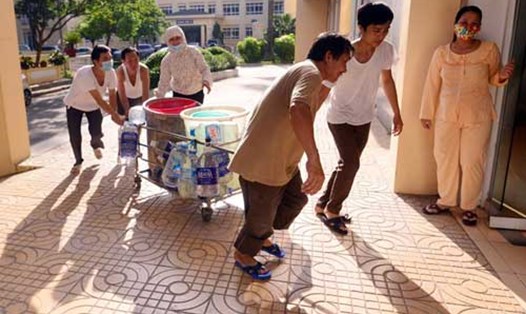 Nhân viên y tế và người nhà bệnh nhân tự túc nước sạch do đường ống Sông Đà bị vỡ (Ảnh Zing)