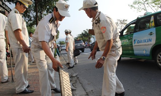 Đội Quy tắc đô thị quận Hải Châu gỡ bỏ các vật liệu xây dựng lấn chiếm vỉa hè, lòng đường trái phép.  Ảnh Hữu Long 