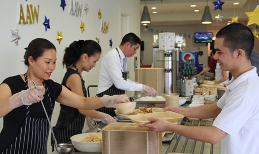 Các thành viên Ban Giám đốc Khách sạn JW Marriott Hanoi phục vụ bữa ăn ca cho nhân viên.