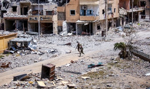 Thành viên lực lượng Dân chủ Syria (SDF) di chuyển trên các con phố đổ nát trong thành Raqqa ngày 28.7. Ảnh: AFP