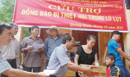 Phó Chủ tịch Tổng LĐLĐVN Nguyễn Văn Ngàng trao quà cho bà con bị thiệt hại vì lũ lụt. Ảnh: H.T