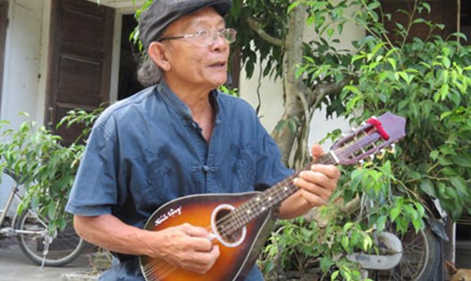 Ông Khánh gảy đàn mandolin và hát dân ca. Ảnh: P.V