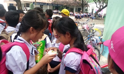 Học sinh lớp 3 trường tiểu học Tam Phước 2 ăn vội cái bánh bao để chuẩn bị vào học ca 2 (suất học từ 10g30 đến 13g30) 