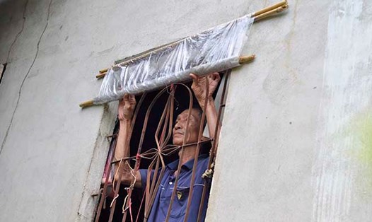 Không được sửa nhà, ông Phạm Văn Thay (57 tuổi) dùng cửa sổ bằng ni-lông để tránh mưa nắng