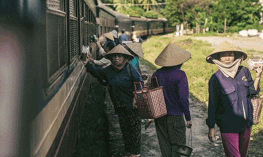 Đoàn tàu Se21 dừng lại ở ga Lăng Cô (Thừa Thiên Huế) để tránh tàu và chuẩn bị leo đèo Hải Vân - đoạn đèo đường sắt dài nhất Việt Nam. Ở nhà ga này vẫn còn nhiều những phụ nữ bán hàng rong mong bán được những món đồ đặc sản cho khách trên tàu. Ảnh: Doãn Qu
