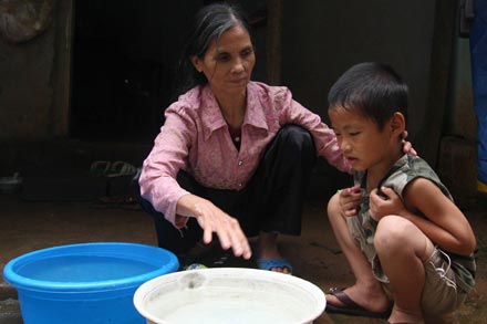 Bà Dương Thị Tuyết mù lòa nhưng phải chăm nuôi cháu bệnh tật. Ảnh: H.Thơ