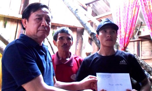 Ông Lê Thuận Văn trao tận tay số tiền hỗ trợ từ Quỹ Tấm lòng vàng Lao Động cho CN Phan Đình Lưu (ở Đội 3, Nông trường 2 Lệ Ninh). Ảnh: Linh Đan