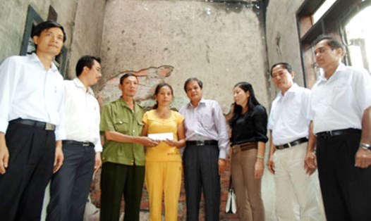 Ông Nguyễn Xuân Toàn trao tiền hỗ trợ từ Quỹ Tấm lòng vàng Lao Động cho gia đình cô giáo Nguyễn Thị Xướng. Ảnh: Linh Đan