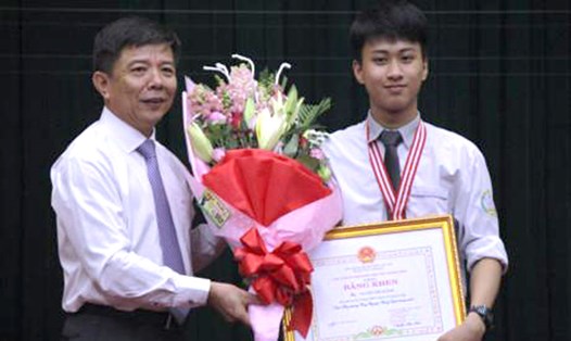 Ông Nguyễn Hữu Hoài, Chủ tịch UBND tỉnh Quảng Bình, trao bằng khen và phần thưởng cho em Nguyễn Thế Quỳnh. Ảnh: VGP