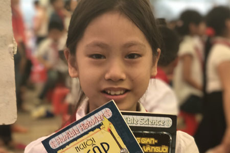 Học sinh Hoằng Hoá, Thanh Hoá vui mừng với cuốn sách được trao tặng. Ảnh: TN