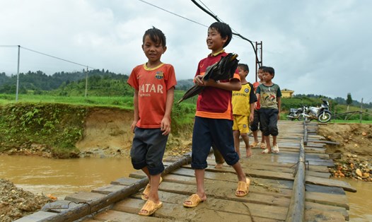 Người dân xã xã Nậm Khắt, huyện Mù Cang Chải đi lại trên cây cầu cũ.