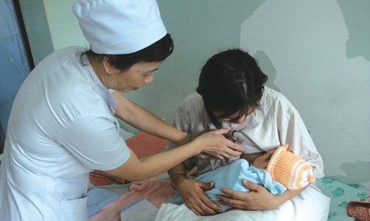 Nữ hộ sinh khoa Hậu sản, BV Hùng Vương, TP.HCM đang hướng dẫn sản phụ cho con bú sữa mẹ.