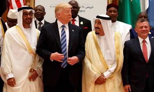 Tổng thống Mỹ Donald Trump trò chuyện với Quốc vương Saudi Saudi Arabi Salman trong lúc họ chụp hình với những nhà lãnh đạo khác tại Hội nghị Thượng đỉnh Hồi giáo Arab Mỹ, ở Riyadh ngày 21.5.2017. Ảnh: AP